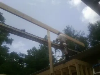 Carpenter setting a ridge beam over a new addition frame — Ice Dam Removal by Roofing Brothers in Chapel Hill