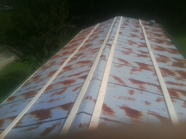 Rusted metal roof panels with new wood purlins before replacement — Storm Damage Roof Repair in Chapel Hill by Roofing Brothers