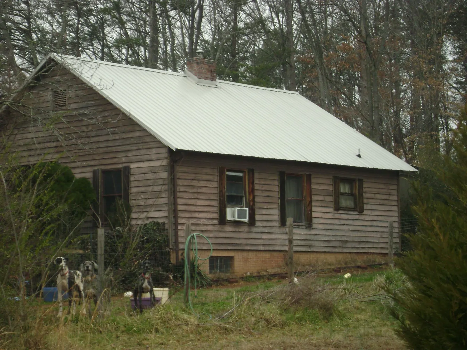White metal roof on an old wood sided farmhouse, from a Metal Roof Installation job in Chapel Hill